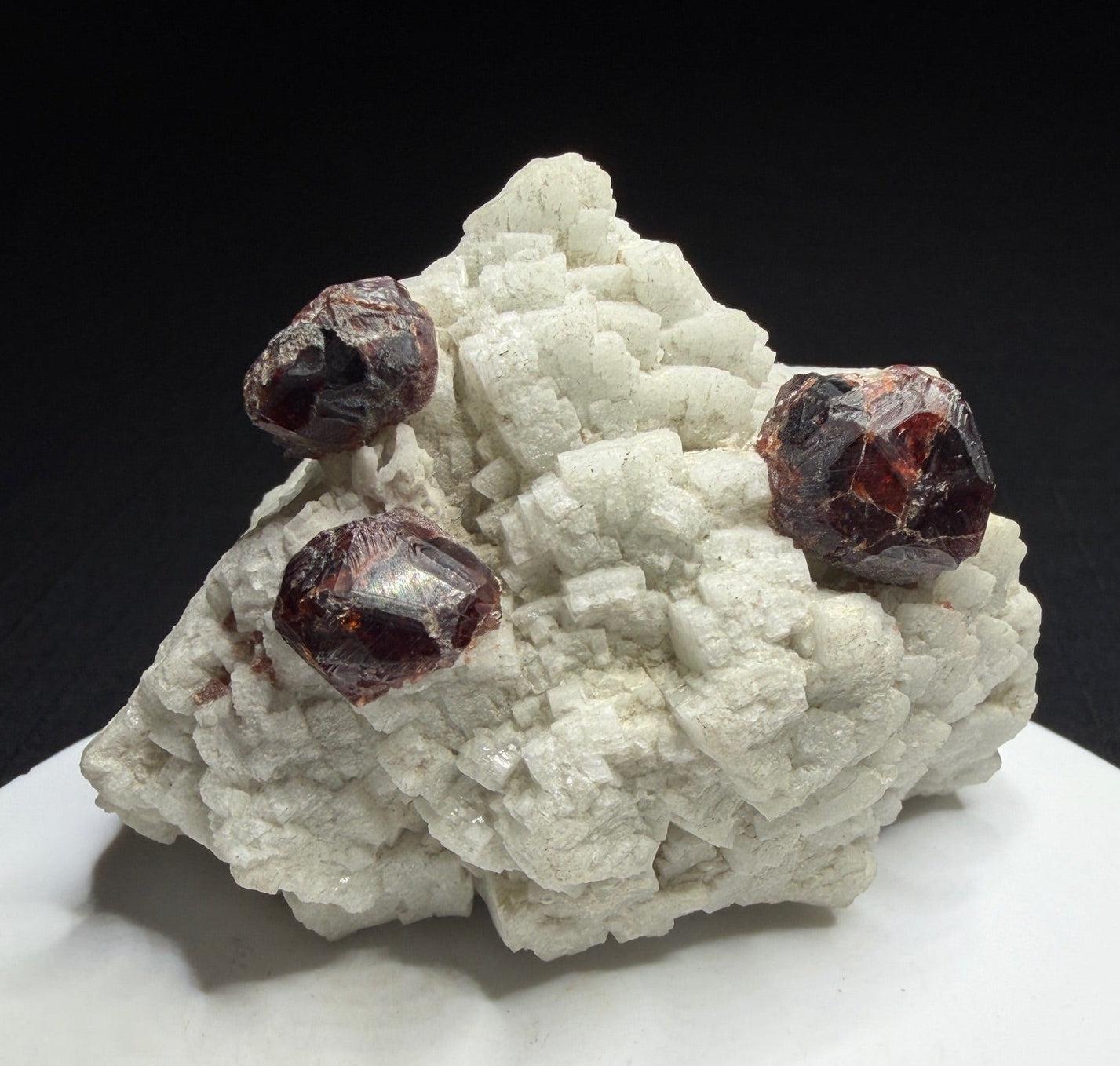 Reddish-brown spessartine garnet crystals on white albite from Shigar Valley, Skardu, Pakistan