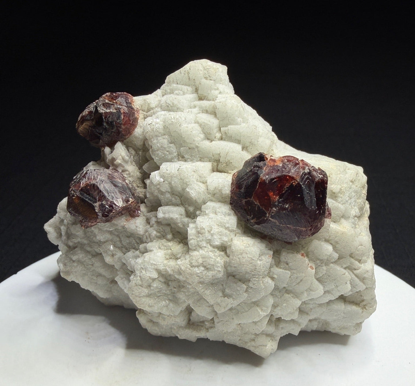 Reddish-brown spessartine garnet crystals on white albite from Shigar Valley, Skardu, Pakistan