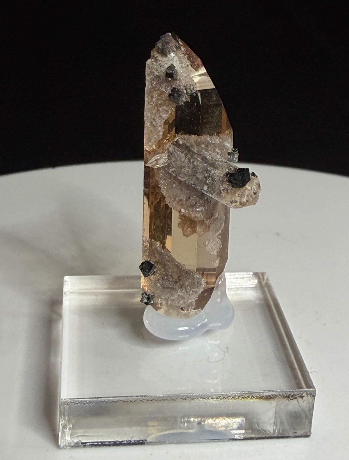 Sherry-colored topaz crystal with black bixbyite crystals from Topaz Mountain, Thomas Range, Utah, USA