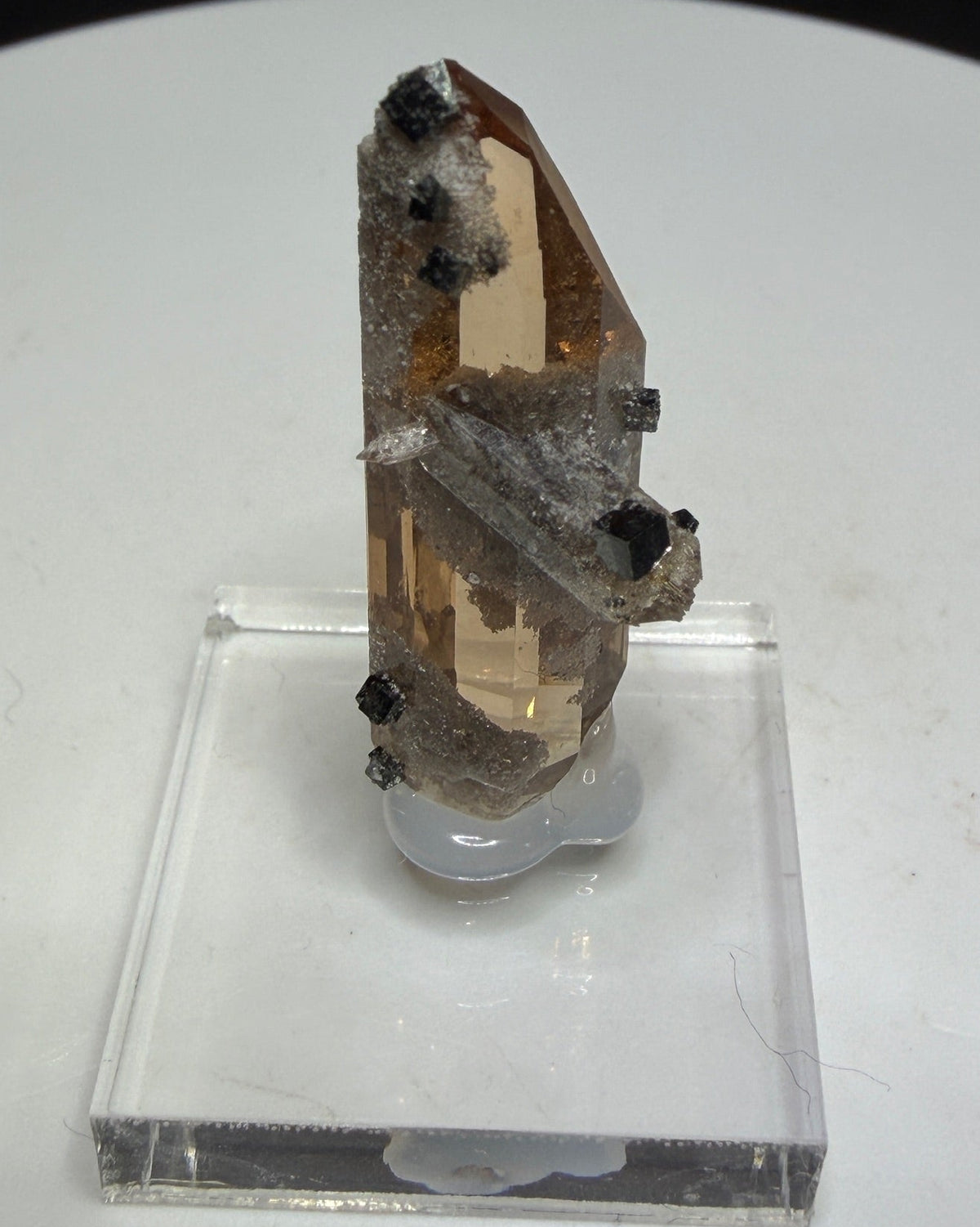 Sherry-colored topaz crystal with black bixbyite crystals from Topaz Mountain, Thomas Range, Utah, USA