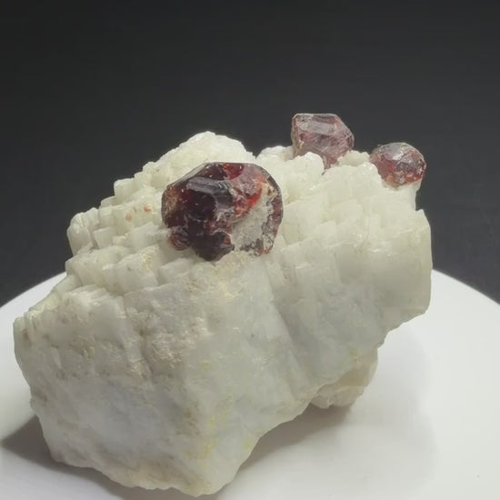 Reddish-brown spessartine garnet crystals on white albite from Shigar Valley, Skardu, Pakistan